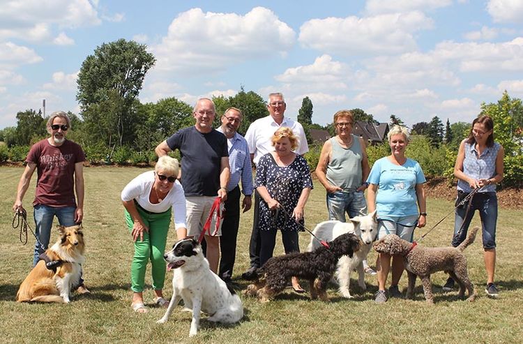 Bezirksbürgermeister Klasmann und RAG Montan Immobilien-Projektleiter Volker Duddek mit begeisterten Hundehaltern auf der Hundewiese in Hassel – früher ein Teil des Kokereiareals. 