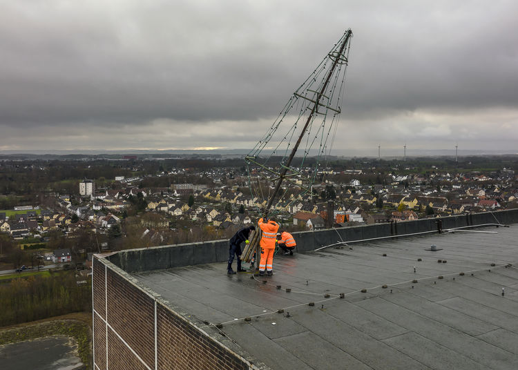 Das städtische Aufbauteam richtet den insgesamt ca. zehn Meter hohen stählernen Weihnachtsbaum auf, der wie eine Schranke per Winde hochgeklappt werden kann. Foto: RAG Montan Immobilien/Thomas Stachelhaus