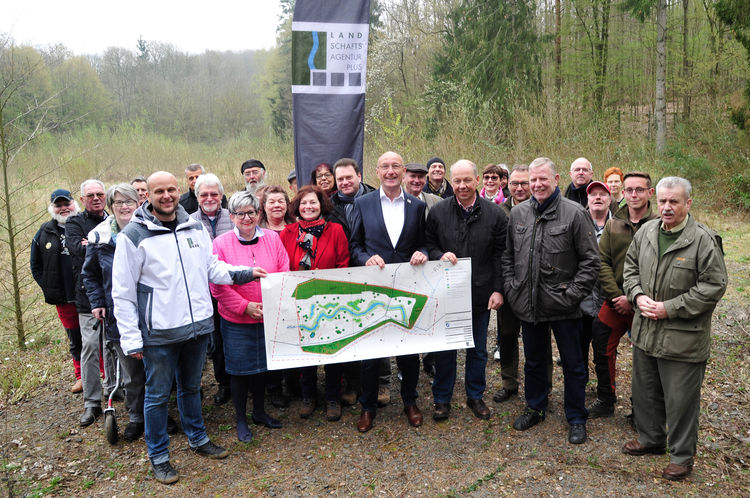 Viele Interessierte folgten der Einladung der Landschaftsagentur Plus GmbH auf das ehemalige Freibadgelände in Sulzbach. Am Übersichtslageplan v.l.n.r.: Michael Boes, Projektingenieur, Martin Strauß, Geschäftsführer, und Rudolf Krumm, Prokurist, alle Landschaftsagentur Plus GmbH, sowie Michael Adam, Bürgermeister der Stadt Sulzbach (2. Reihe, Mitte). Foto: RAG Montan Immobilien (Becker&Bredel / Laura Ockenfels). 