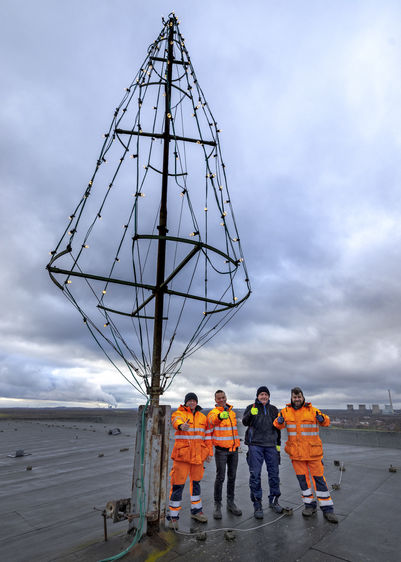 Das Aufbauteam auf dem Dach hat den Baum aufgerichtet und der Leuchttest ist erfolgreich absolviert. Das Team: Maxim Kiritschenko, Christian Breßler, Michael Hoffmann und Mario Brugger (v.l.nr.) Foto: RAG Montan Immobilien/Thomas Stachelhaus