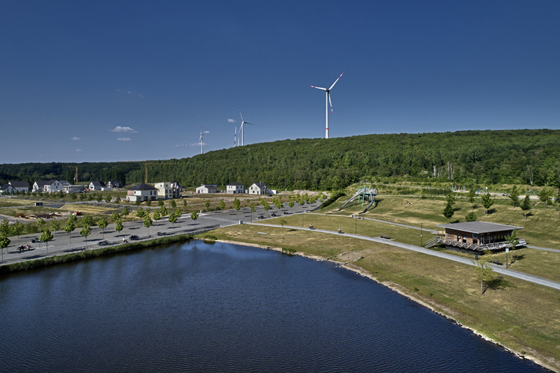 See mit Windrädern im Hintergrund